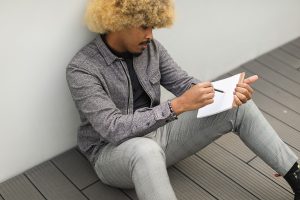Guy sitting on deck drawing